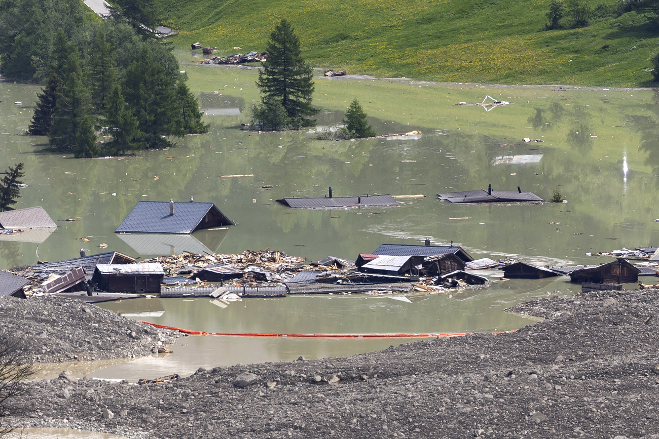 Check dams have been set up on the water from the Lonza river flows over the mud and stone, after the formation of a lake on the last houses of the village of Blatten, Switzerland, Saturday, May 31, 2025. A large part of the village of Blatten, located in the Loetschental Valley in the canton of Valais, was buried under masses of ice, mud, and rock. Numerous houses were destroyed, and one person is missing. Between May 19 and 28, several million cubic meters of rock fell from the Kleines Nesthorn mountain above Blatten. This created a nine-million-tonne debris cone on the Birch Glacier, which ultimately collapsed on May 28, 2025. (KEYSTONE/Cyril Zingaro)